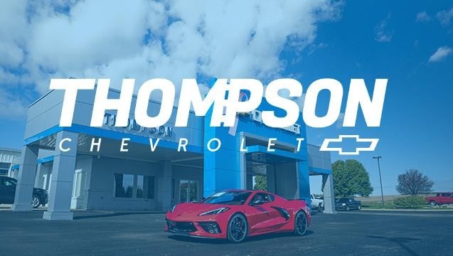Thompson Chevrolet exterior dealership with red corvette parked outside